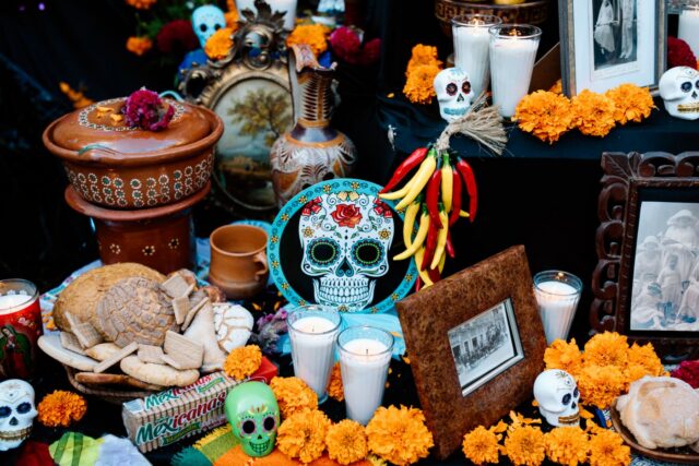 Altare del Día de los Muertos con teschio di zucchero, calendule e pan de muerto